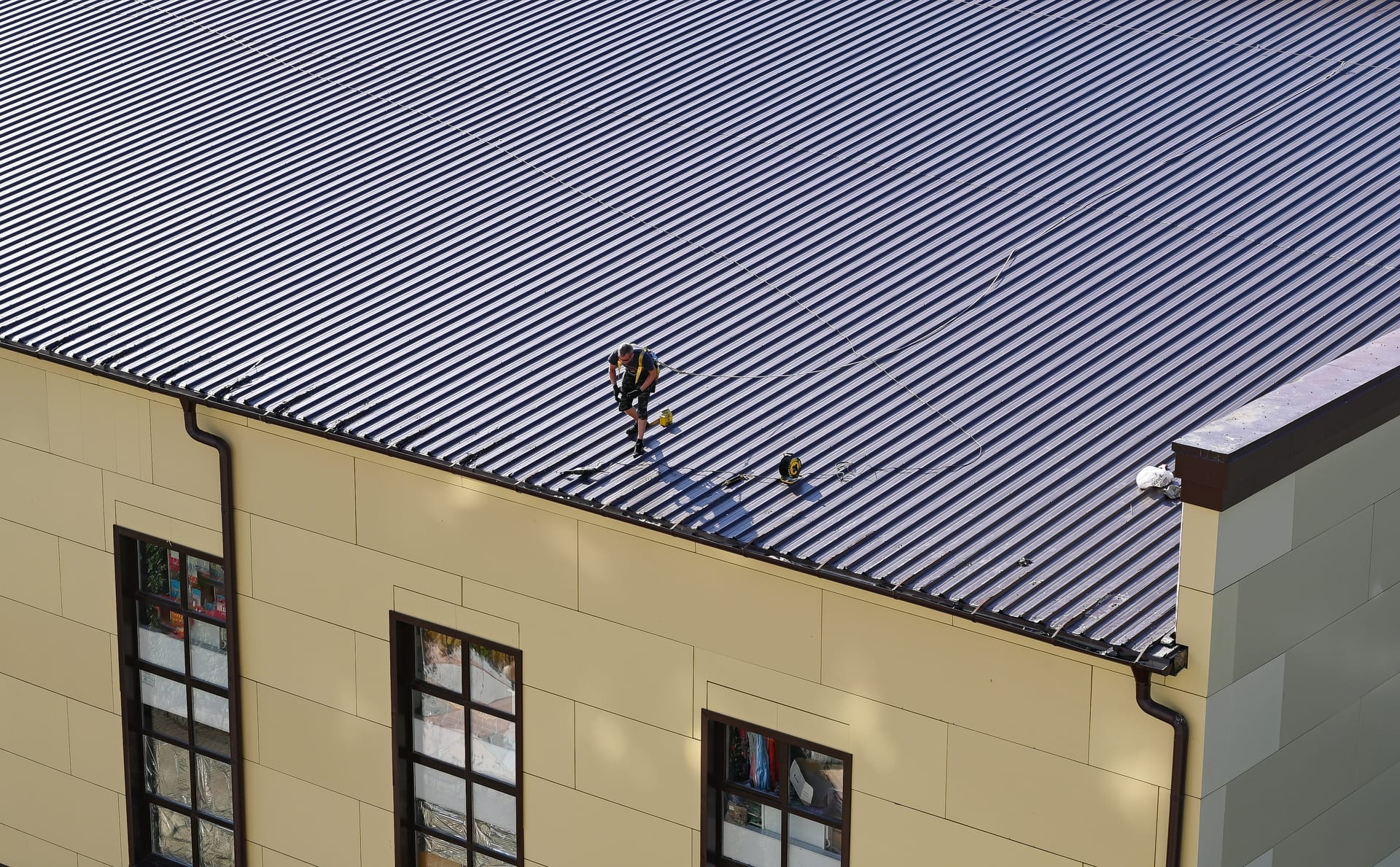 Roofer working on a standing seam metal roof in Florida by Best Florida Roofing